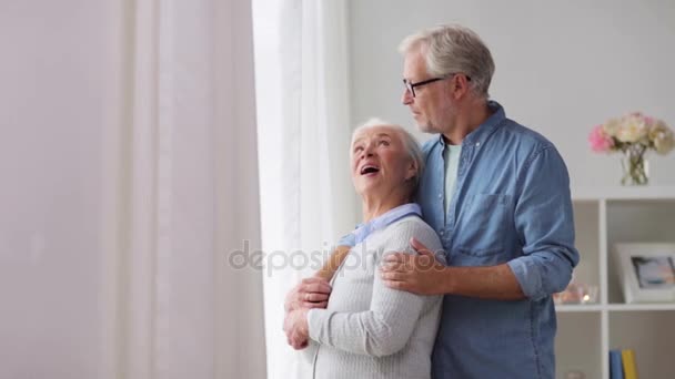 Счастливая пожилая пара смотрит в окно дома — стоковое видео