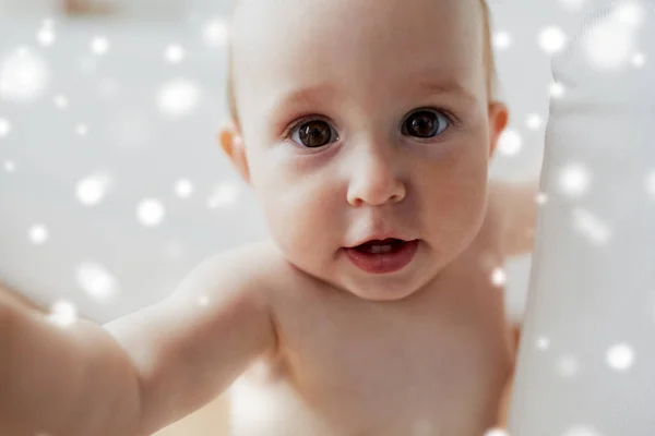 Närbild på glada lilla bebis över snö — Stockfoto
