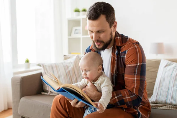 Glücklicher Vater und kleiner Junge mit Buch zu Hause — Stockfoto