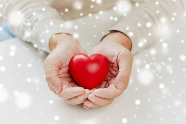 Primo piano di uomo più anziano con cuore rosso in mani — Foto Stock