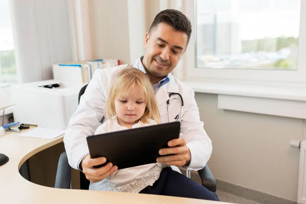 Врач и маленькая девочка с планшетным ПК в клинике — стоковое фото