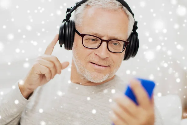 Hombre mayor feliz con teléfono inteligente y auriculares —  Fotos de Stock