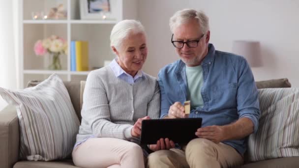 Casal sênior feliz com tablet pc e cartão de crédito — Vídeo de Stock