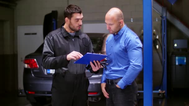 Monteur en klant schudden van handen bij car-service — Stockvideo