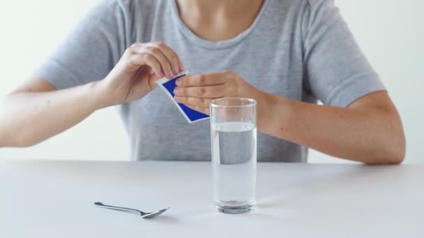 Женщина перемешивает лекарства в стакане воды — стоковое видео