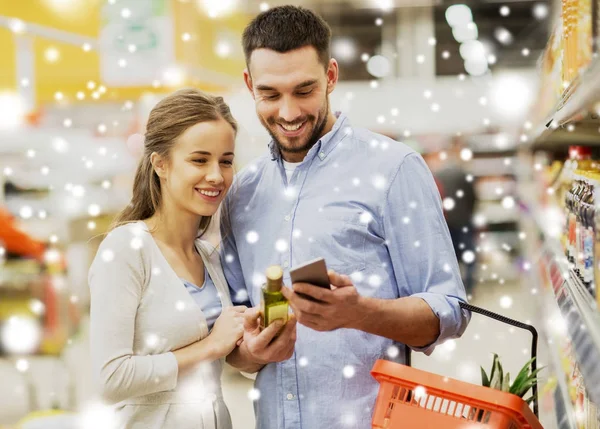 Couple avec smartphone acheter de l'huile d'olive à l'épicerie — Photo