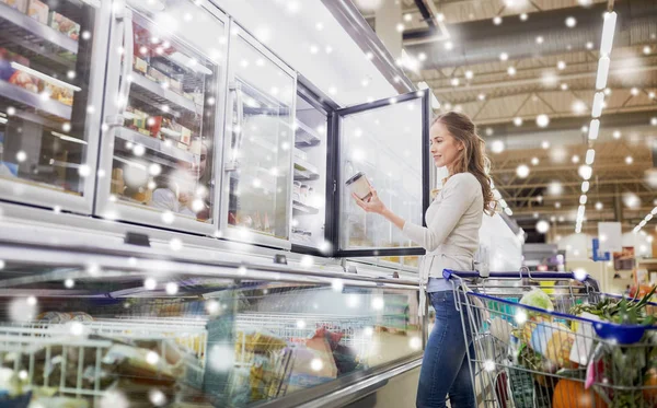 Vrouw ijs bij supermarkt diepvriezer kiezen — Stockfoto