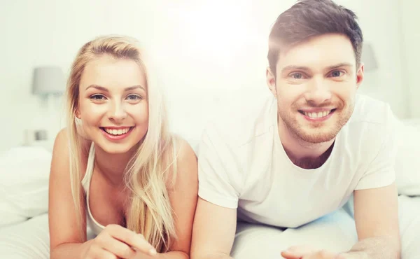 Feliz pareja acostada en la cama en casa — Foto de Stock