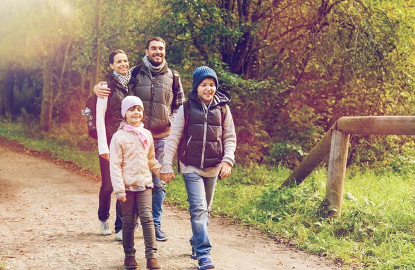 Lycklig familj med ryggsäckar vandring i skogen — Stockfoto