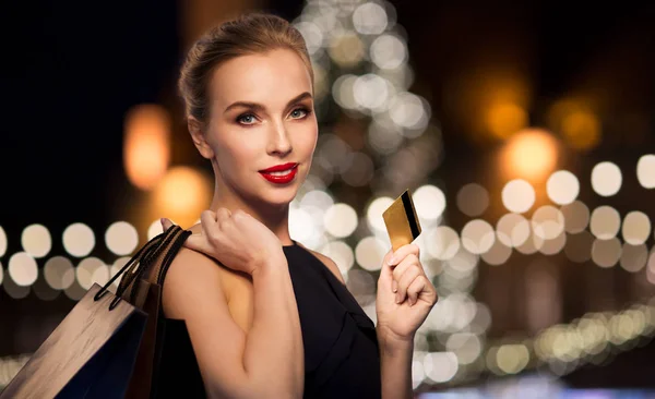 Mujer con tarjeta de crédito y bolsas de compras — Foto de Stock