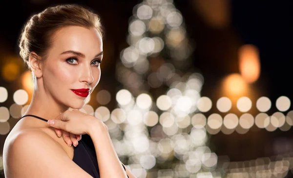 Vacker kvinna över julgransljus — Stockfoto