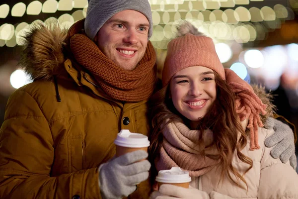 Coppia felice con caffè sopra le luci di Natale — Foto Stock