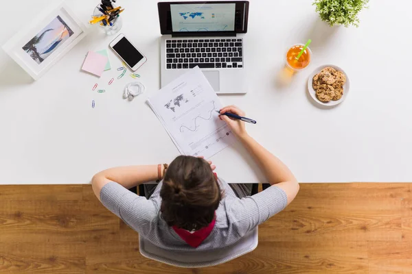 Vrouw met laptop en papieren aan Bureau tafel — Stockfoto