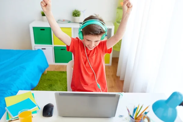 Boy with headphones playing video game on laptop — Stock Photo, Image