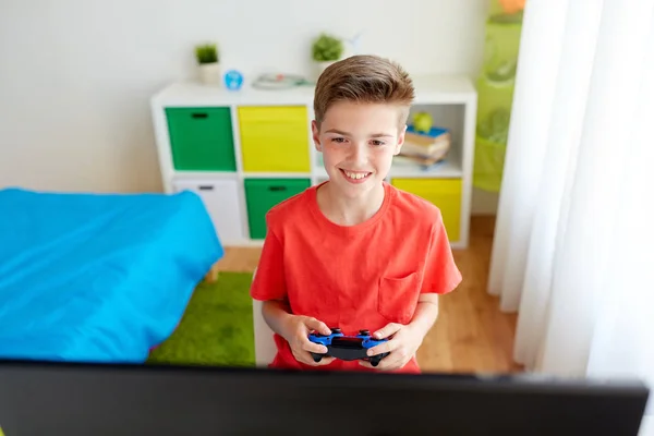 Niño con gamepad jugando videojuego en el ordenador — Foto de Stock