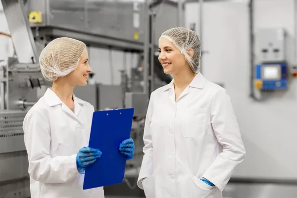 Mujeres felices tecnólogos en la fábrica de helados — Foto de Stock