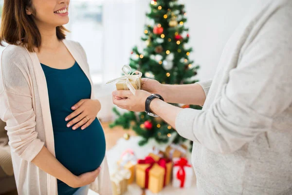 Marido dando presente de Natal à esposa grávida — Fotografia de Stock