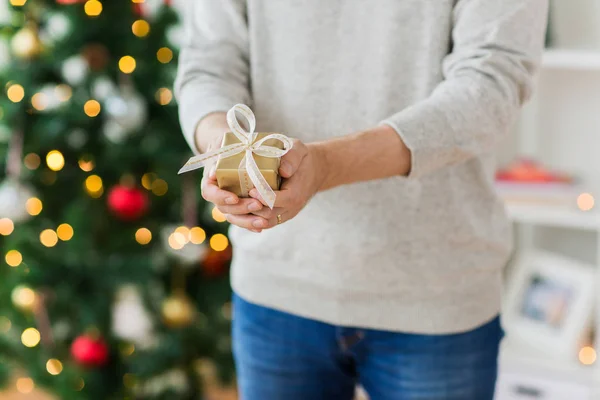 Zbliżenie na człowieka z prezent na Boże Narodzenie w domu — Zdjęcie stockowe