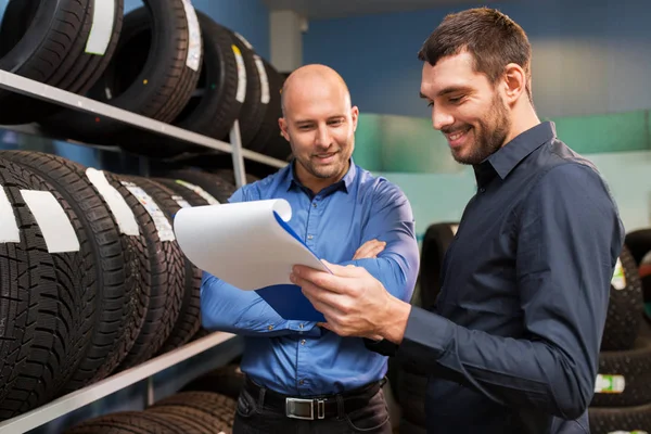 Customer and salesman at car service or auto store — Stock Photo, Image