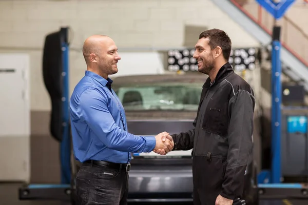 Monteur en klant schudden van handen bij car-service — Stockfoto