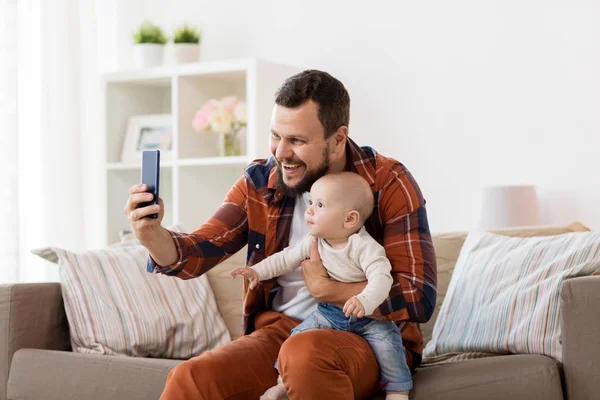 Feliz padre con bebé niño tomando selfie en casa —  Fotos de Stock
