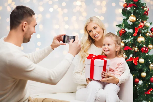 Homem fotografando sua família com presente de Natal — Fotografia de Stock