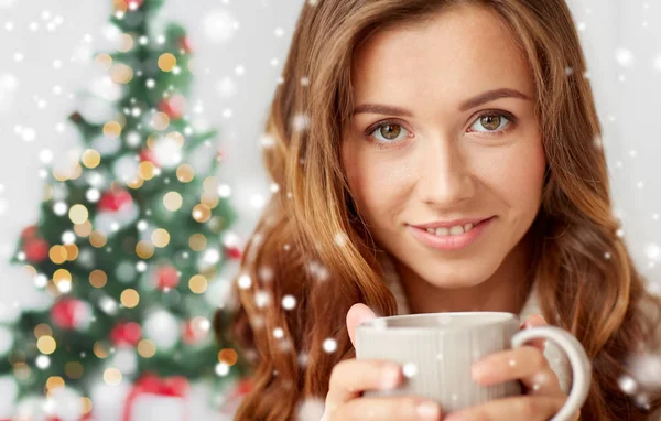 Primer plano de la mujer con taza de té sobre el árbol de Navidad —  Fotos de Stock