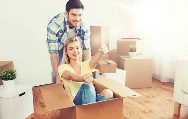 Feliz pareja divirtiéndose con cajas en nuevo hogar — Foto de Stock