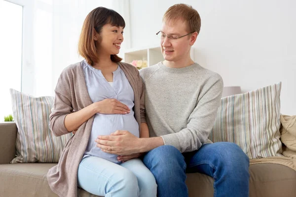 Glada gravida fru med make hemma — Stockfoto