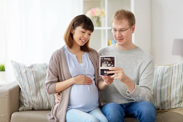 Glückliches Paar mit Ultraschallbildern zu Hause — Stockfoto