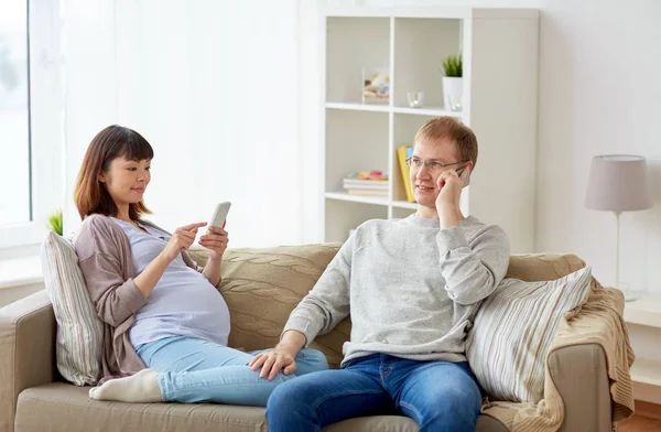 남편과 집에서 스마트폰으로 임신 아내 로열티 프리 스톡 이미지
