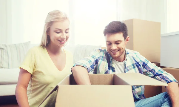 Lächelndes Paar mit großen Kisten zieht um — Stockfoto
