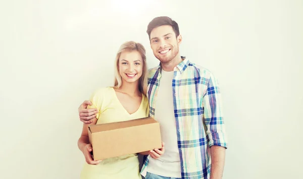 Улыбающаяся пара с коробкой, переезжающая в новый дом — стоковое фото