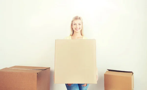 Sonriente joven con caja de cartón en casa —  Fotos de Stock