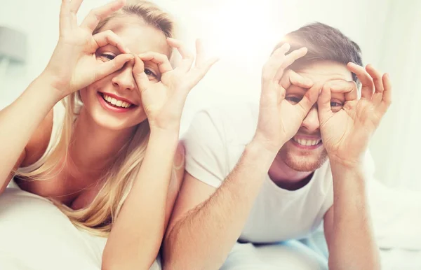 Happy couple lying in bed at home — Stock Photo, Image