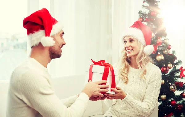 Feliz pareja en casa con caja de regalo de Navidad — Foto de Stock