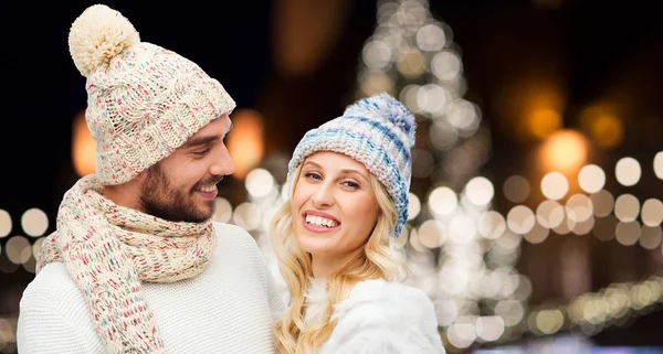 Gelukkige paar knuffelen over Kerstverlichting — Stockfoto