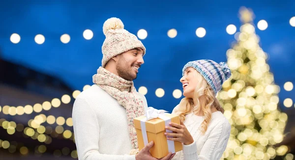 幸福的夫妇与礼品盒在圣诞灯 — 图库照片