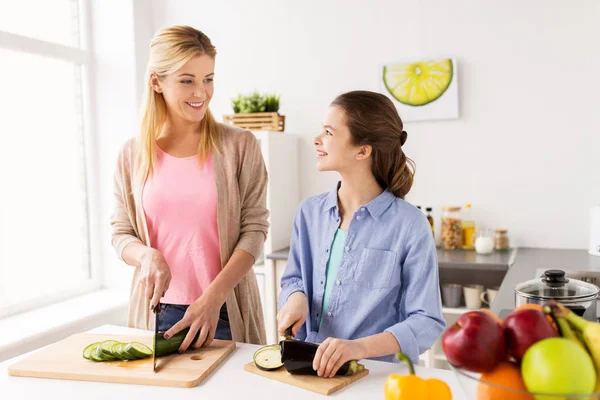 Happy family cooking vegetables at home kitchen — Stock Photo, Image