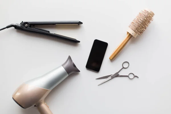 Smartphone, schaar, haardroger, strijkijzer en borstel — Stockfoto