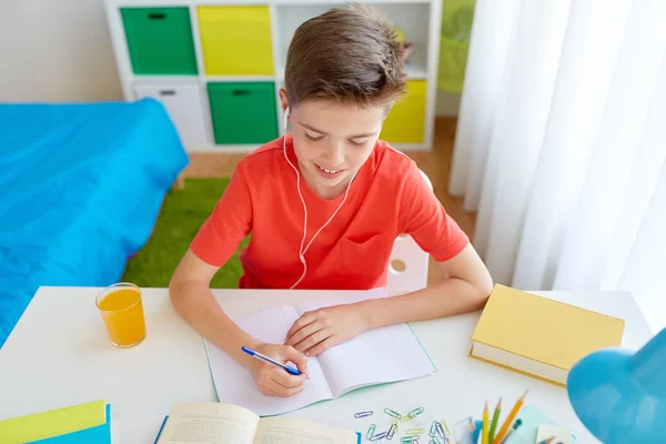 Student szczęśliwy chłopiec piśmie do notebooka w domu — Zdjęcie stockowe