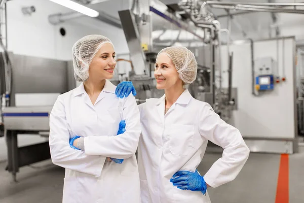 Счастливые женщины-технологи на фабрике мороженого — стоковое фото
