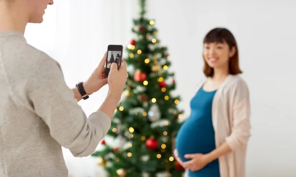 Marido fotografiando embarazada fife en Navidad — Foto de Stock