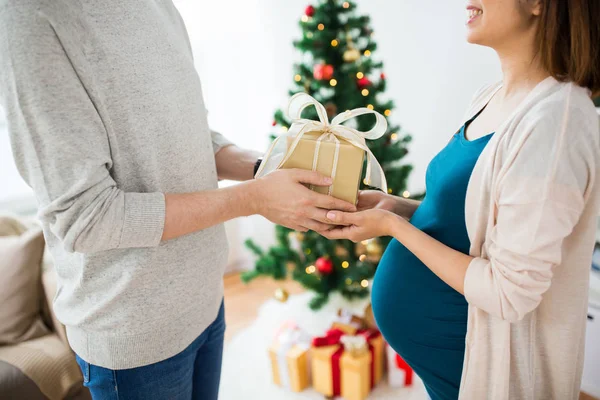 Marido dando presente de Natal à esposa grávida — Fotografia de Stock