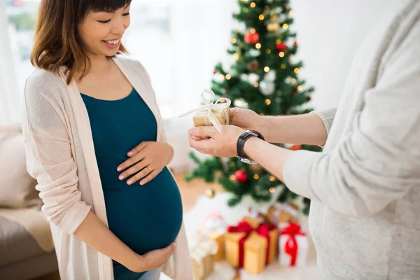 Echtgenoot van geven kerstcadeau aan zwangere vrouw — Stockfoto