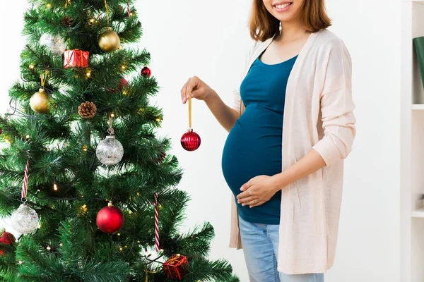 Zwanger vrouw versieren kerstboom — Stockfoto