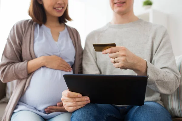 Мужчина и беременная жена совершают покупки в Интернете — стоковое фото