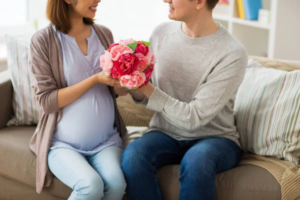 Close-up de homem dando flores para a esposa grávida — Fotografia de Stock