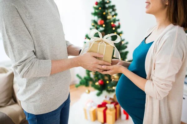 Marido dando presente de Natal à esposa grávida Fotos De Bancos De Imagens Sem Royalties