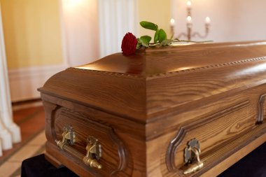 red rose flower on wooden coffin in church clipart